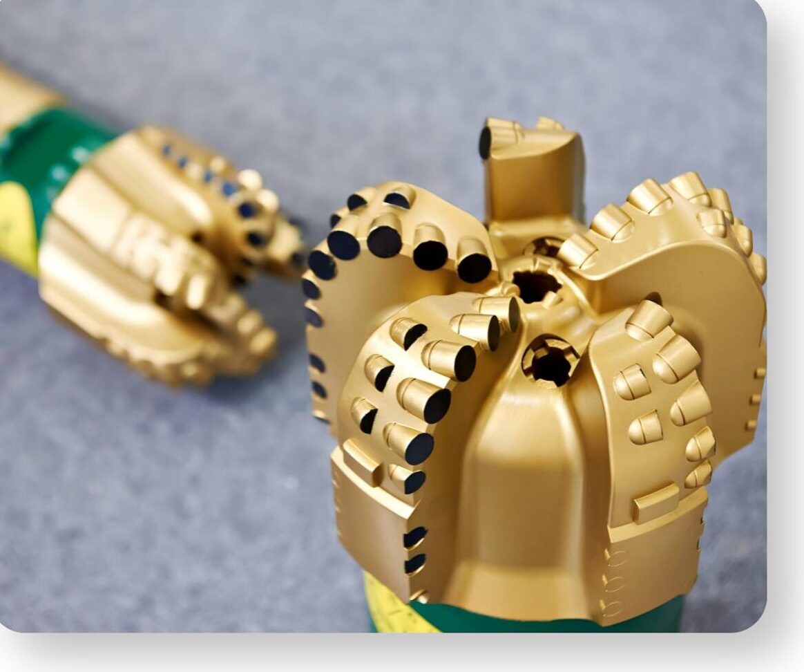 A gold finished polycrystalline diamond compact drill bit, photographed close up